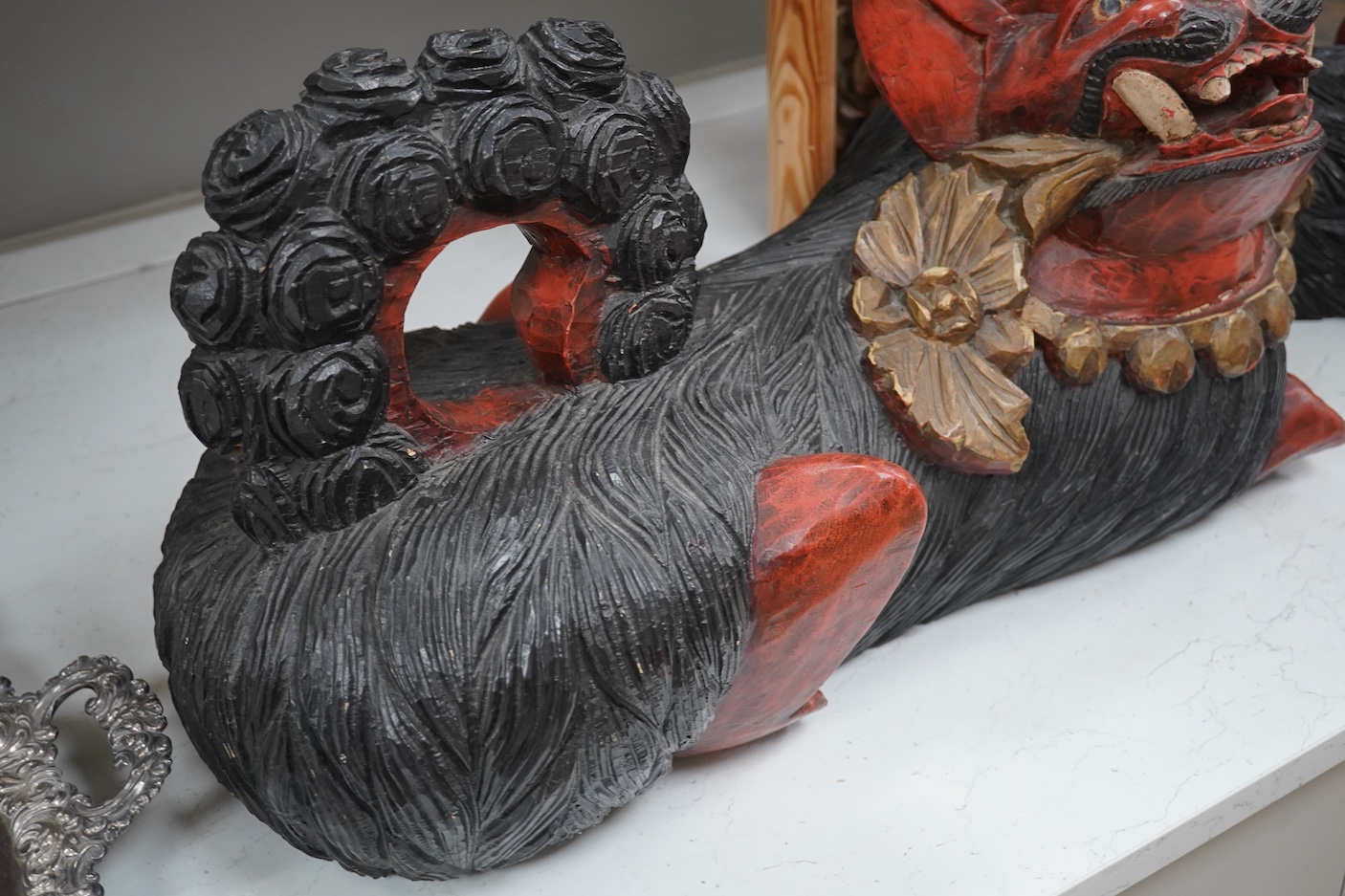 A pair of large Indonesian carved and painted wood lion dogs, 67cm wide.